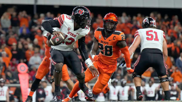 Sep 29, 2023; Corvallis, Oregon, USA; Utah Utes quarterback Nate Johnson (13) scrambles under pressure from Oregon State Beavers defensive back Kitan Oladapo (28) during the second half at Reser Stadium. Mandatory Credit: Soobum Im-USA TODAY Sports